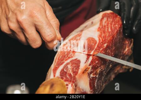 Stock photo d'une main d'un maître de jambon ibérique Cutter. Il coupe le jambon ibérique Banque D'Images