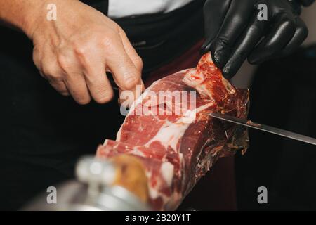 Stock photo d'une main d'un maître de jambon ibérique Cutter. Il coupe le jambon ibérique Banque D'Images