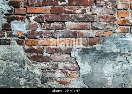 Mur de briques rouges délabré, ancienne façade en ruines. Grunge urbaine stonewall, bâtiment détruit, architecture de ciment Banque D'Images