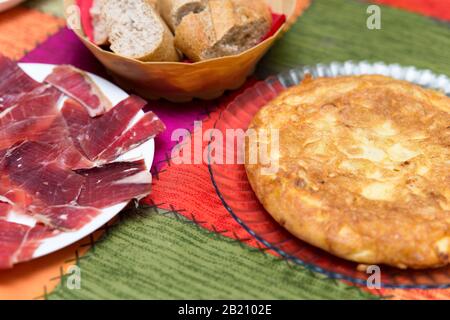 gros plan de assiettes avec omelette aux pommes de terre espagnoles et jambon serrano servi Banque D'Images