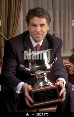 Austin , Texas - le gouverneur du Texas Rick Perry tient la coupe du gouverneur donnée à l'État du Texas par site Selection Magazine comme le meilleur état dans lequel déplacer une entreprise pour 2004. Le Texas et la Californie sont dans une bataille acharnée pour attirer leur part de nouvelles délocalisations d'affaires. ©Bob Daemmrich Banque D'Images