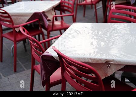 des chaises et des tables de restaurant vides par mauvais temps en basse saison. Banque D'Images