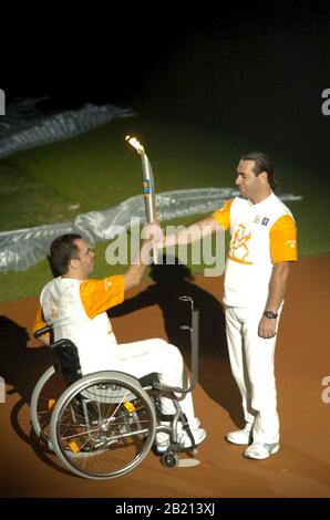 Athènes, Grèce 17SEP04: Transfert de la torche dans le cadre du relais de la torche olympique lors de la cérémonie d'ouverture aux Jeux paralympiques d'Athènes. ©Bob Daemmrich Banque D'Images