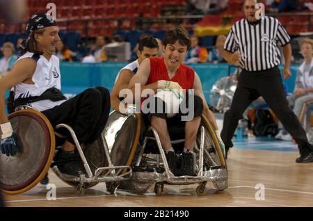 Jeux paralympiques d'Athènes : action de rugby en fauteuil roulant pour hommes Belgique (rouge) Ludwig Budgers marque un but contre l'Allemagne (blanc). ©Bob Daemmrich Banque D'Images