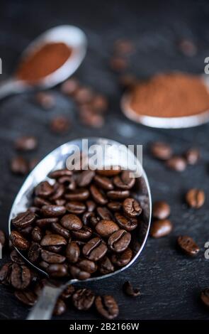 Cuillères sur une table remplie de grains de café et de poudre de café Banque D'Images