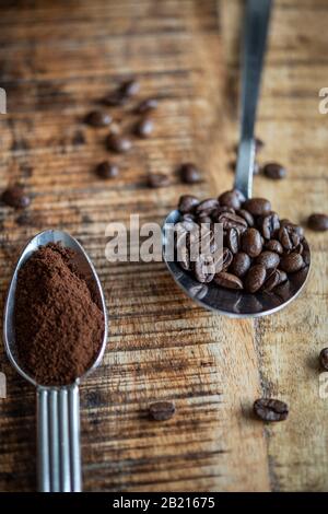 Cuillères sur une table remplie de grains de café et de poudre de café Banque D'Images