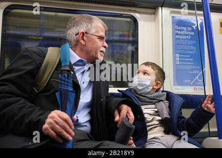 Enfant portant un masque facial comme protection contre le coronavirus, dans le métro de londres Banque D'Images