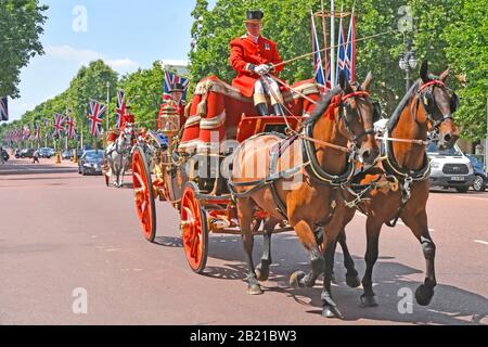 Gros plan sur deux voitures d'État tracées à cheval dans le Mall Coachman & Footman en uniforme transportant des dignitaires diplomatiques Union drapeaux Londres UK Banque D'Images