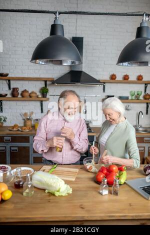 Couple d'aînés qui font une salade pour un dîner ensemble Banque D'Images