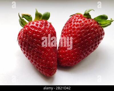Deux fraises fraîches sur fond blanc. Vue rapprochée, vue de dessus. Banque D'Images