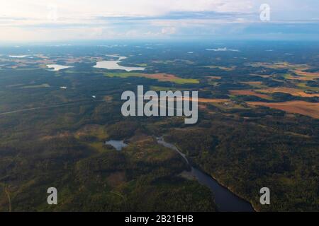 Vue aérienne de la campagne suédoise avec les terres agricoles, les forêts vertes et les champs de blé vus de l'avion volant à l'aéroport de Scavsta après la tempête estivale Banque D'Images