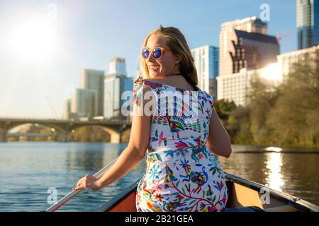 Heureuse, joyeuse et gaie jeune femme dans des lunettes de soleil profitant d'une chaude journée d'été avec des activités aquatiques, canotage, kayak et canoë à Austin Texas Banque D'Images