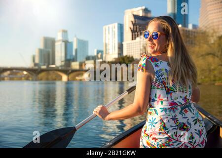 Un voyageur magnifique qui profite d'une aventure touristique, kayak la rivière près d'une ville urbaine en été Banque D'Images