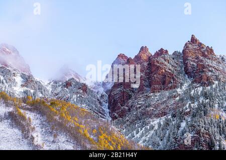 Vue sur le lever du soleil de Maroon Bells dans les montagnes rocheuses d'Aspen à l'élan rouge dans le Colorado et neige à la fin de l'automne avec couverture de nuages de brouillard d'hiver Banque D'Images