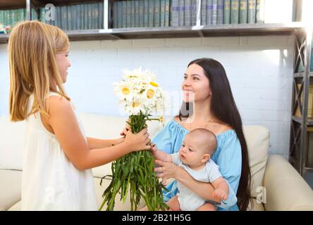 Petite fille donnant bouquet de belles fleurs à sa mère. Concept de la fête des mères Banque D'Images