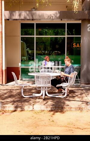 Les gens qui profitent du soleil de début de printemps pendant l'heure du déjeuner sur le campus de l'Université de l'Arizona à Tucson Banque D'Images