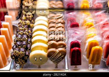 De nombreux popsicles jaunes rouges dans le magasin de la crème glacée dans la célèbre Florence Italie Firenze Centrale Mercato et des sucettes de gâteau au chocolat Banque D'Images