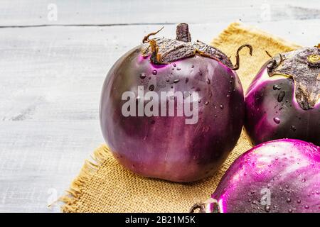 Aubergines rondes bio fraîches de qualité « Helios ». Concept de cuisine végétalienne (végétarienne) saine. Sur toile de fond en toile de fond en bois gris, copier sp Banque D'Images