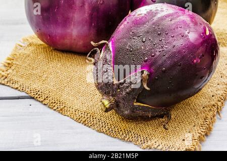 Aubergines rondes bio fraîches de qualité « Helios ». Concept de cuisine végétalienne (végétarienne) saine. Sur toile de fond en toile de fond en bois gris, copier sp Banque D'Images