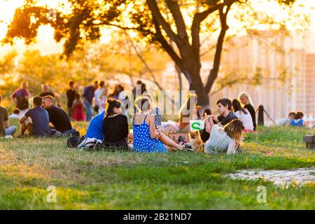 Kiev, Ukraine - 10 août 2018: Allée de paysage dans la capitale de Kiev centre-ville pendant coucher de soleil doré avec beaucoup de personnes assis ayant pique-nique Banque D'Images