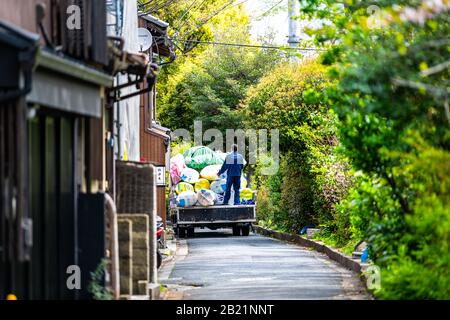 Kyoto, Japon - 17 avril 2019: Quartier près du canal de la rivière Takase avec des plantes vertes et des gens des ordures sur la rue nettoyage ramassage des ordures Banque D'Images