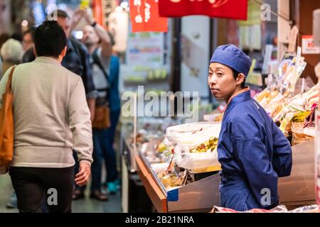 Kyoto, Japon - 17 avril 2019: Les gens de la ville dans les magasins du marché de Nishiki avec le chef de la vente de nourriture homme vendant des fruits de mer avec uniforme Banque D'Images