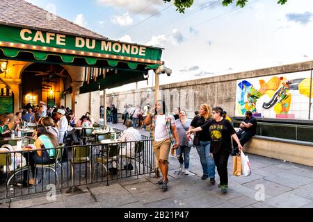 New Orleans, USA - 22 avril 2018: Les gens en ligne qui attendent d'entrer dans le restaurant café du monde signe manger beignet poudre de sucre beignet et coff de chicorée Banque D'Images