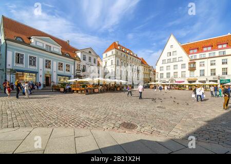 Les touristes peuvent profiter d'un après-midi d'été pour manger dans les cafés et les magasins de la place de la vieille ville dans le centre touristique médiéval de Tallinn Estonie. Banque D'Images