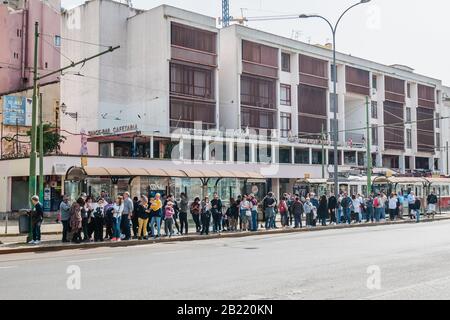 Longue gamme de personnes touristes visiteurs en attente de tram ou de transport public dans le secteur de Martim Moniz de Lisbonne Portugal Banque D'Images