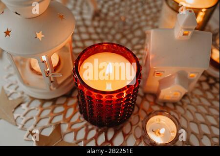 Décoration de table blanche pour Noël et le nouvel an, bougies blanches et rouges, chandelier de forme lanterne sur serviette brune en osier, guirlandes et un Banque D'Images