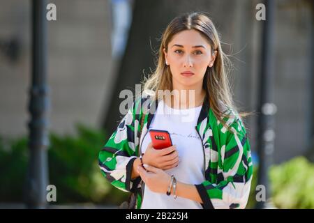 Une femme blonde avec un téléphone portable marchant dans l'avenue Shota Rustaveli, Tbilissi, Géorgie Banque D'Images