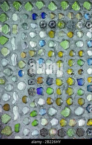 Les pièces en verre de couleur sont collées sur la surface en béton. Un motif décoratif a été créé. Banque D'Images