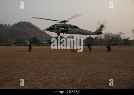 Loppuri, Thaïlande – Soldats thaïlandais de l’unité d’opération spéciale, la Garde du roi, aux côtés d’un Beret vert de l’armée américaine du premier groupe des forces spéciales (aéroporté), répétitions de mouvements après un rapide vol d’un hélicoptère Sea Hawk de la marine américaine MH-60 affecté aux « pompiers » de l’escadron de combat d’hélicoptère marin (HSC) 85 le 25 février, 2020, au camp d'Erawan, Lophburi, Royaume de Thaïlande, à l'appui de Cobra Gold. L'exercice Cobra Gold 20, dans sa 39ème itération, est conçu pour promouvoir la sécurité régionale et assurer des réponses efficaces aux crises régionales en rassemblant des forces multinationales pour atteindre des objectifs communs Banque D'Images