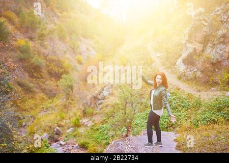 Female hiker prenant en selfies forêt montagnes. Touriste avec sac à dos est dans une gorge de montagne sous le coucher du soleil. Banque D'Images