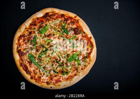 Pizza italienne avec légumes verts sur la table noire avec espace de copie Banque D'Images