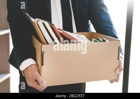 Les jeunes hommes d'affaires tristes Ont Tiré des boîtes, y compris une usine de pot et des documents pour le chômage des biens personnels, concept résigné Banque D'Images