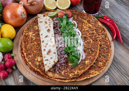 Cuisine turque délicieuse pizza Lahmacun avec viande hachée de bœuf ou d'agneau, paprika, tomates, épices de cumin, épicé au persil. Banque D'Images