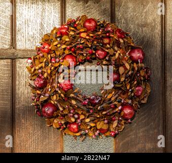 Couronne de Noël sur la porte de la maison faite de brindilles, de feuilles séchées, et de pommes, Royaume-Uni Banque D'Images