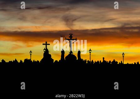 Silhouettes de statues du pont Charles (Karluv Most) au coucher du soleil jaune Banque D'Images