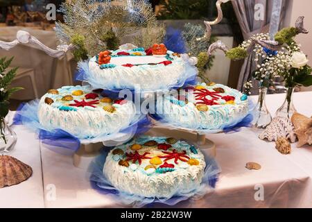 La beauté de l'enfance avec une fête de couleur marine avec des gâteaux couverts de crème douce et des amandes sugarées multicolores en forme d'animal de mer . Banque D'Images