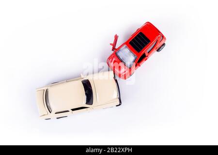 Deux mini-crash de voiture jouet, incident, accident de la circulation automobile, vue supérieure de collision frontale, concept abstrait d'assurance automobile, voitures cassées endommagées, fissurées Banque D'Images