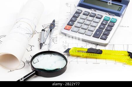 Électricien, ingénieur sur le lieu de travail, table avec feuilles de papier blanc trace, schémas et divers outils concept. Loupe, calculatrice Banque D'Images