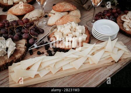 Assiette de fromage servie avec des raisins, de la confiture, des figues, des craquelins et des noix sur fond de bois. Vue de dessus. Banque D'Images