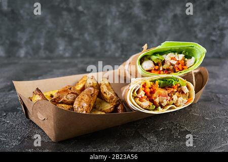 Délicieux sandwich au shawarma avec poulet et pomme de terre sur fond en bois Banque D'Images