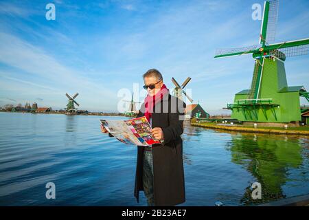 L'homme avec une carte traverse le musée en plein air de Zaanse Schans Banque D'Images