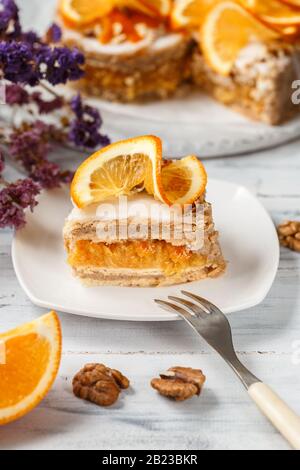 Un morceau de gâteau orange sur Un Plat carré avec fourche prête à manger Banque D'Images