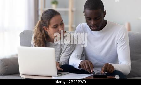Homme africain américain utilisant la calculatrice, famille calculer la finance à la maison Banque D'Images