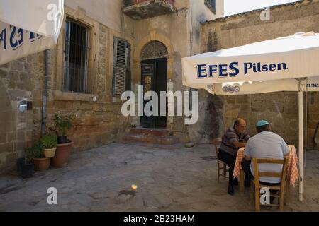 Déjeuner pour deux vieux hommes dans un vieux café (café Müze Dostları) en face de la mosquée, Zühtüzade Sokak, Nicosie du Nord, Chypre turque Banque D'Images
