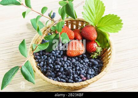 Baies fraise mûre brillante et chèvrechèvante Extrême-Orient dans un panier en osier sur la table Banque D'Images