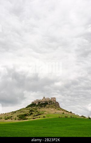 ruines du château de spis lors d'une journée nuageux au printemps. célèbre destination touristique de la slovaquie. Patrimoine de l'UNESCO. Prairie herbeuse au pied de la colline. Banque D'Images